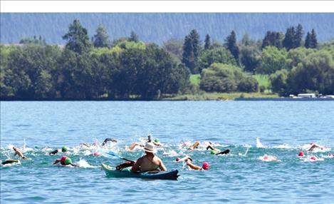 A kayaker keeps an eye on the Water Daze swimmers as they start from Salish Point.