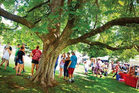 An enormous buckeye tree shades visitors attending the Sandpiper Outdoor Art Festival Saturday on the lawn of the Lake County Courthouse in Polson.