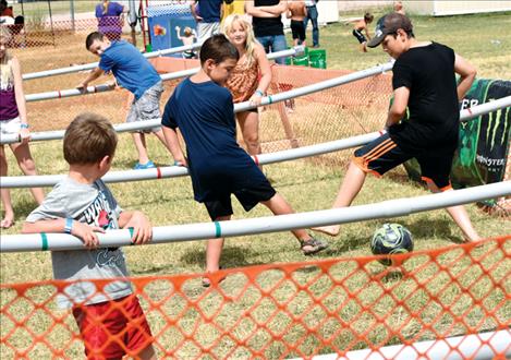 Kids play a life-size game of foosball.