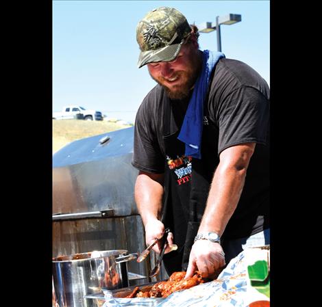 Max Nash, Hog Boss Catering, serves up some barbecue at Smokin’ On the Water on Aug. 1.