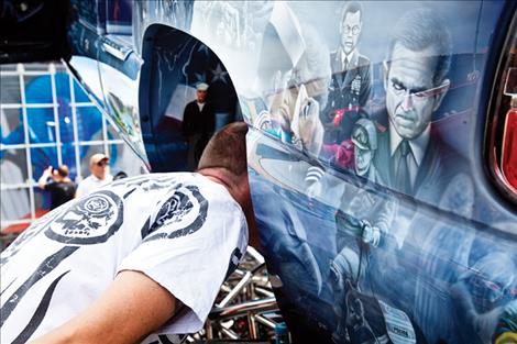  A motorhead examines the engine of a car.  