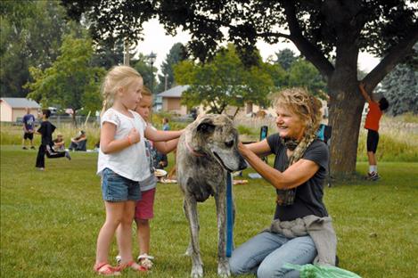 Sadie, the Ronan Library story time mascot, visits with admirers as story time leader Andrea Dunn looks on.