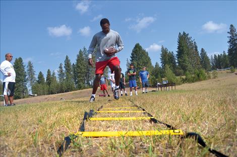 Former NFL cornerback Mike Haynes demonstrates a quickness drill Saturday during the Big 3 Sports Clinic held at Salish Kootenai College. Haynes, a former Raider and Patriot, is a Super Bowl Champion, a nine-time Pro Bowler and was inducted into the NFL Hall of Fame. Below, former NBA all-star Otis Birdsong coaches a group of young ladies.