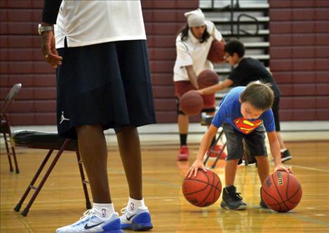 Tony Lozeau, 6, tries to dribble with two balls