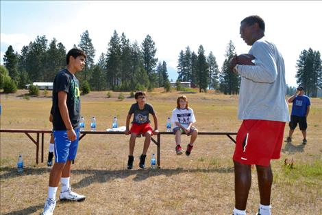 Jony Perez, 12, standing, listens as Mike Haynes offers sage advice while Connor Burke,12, seated left, and Nic Frost, 10, also pay attention.