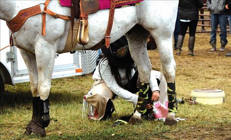 Miss Indian Rodeo Devalyn Crowe, left, wraps her horse’s legs in peace signs before an evening performance of the Flathead River Rodeo.