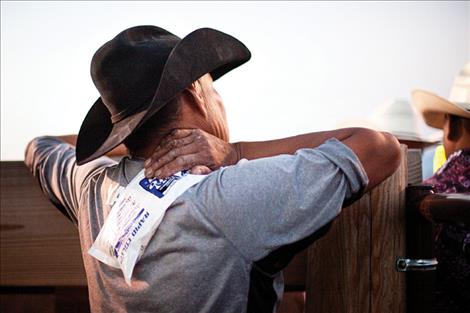 A rodeo competitor ices a shoulder injury while watching the show.