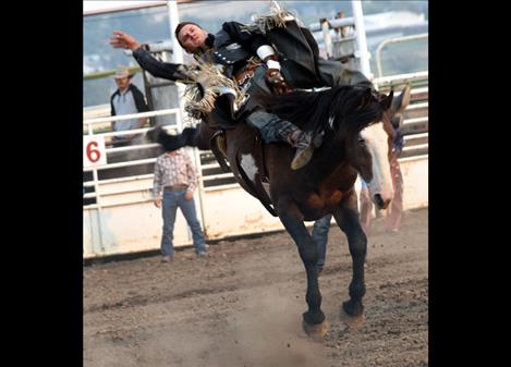 Buck Lunak  takes a wild ride on a bareback bronc.