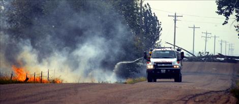 WInds cause a tree to fall across North Reservoir Road Friday, downing a power line and igniting a wind-driven grassfire that threatened the shelter.