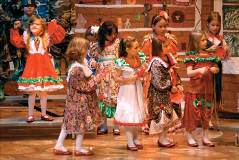Sparkly red shoes and ruffly dresses adorn the “dolls” in Santa’s workshop. 
