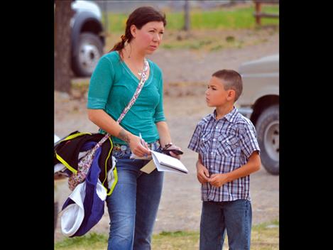 Lisa Houle and her son Gabriel Brown consider the prices as the auction continues. Brown, self-proclaimed math whiz, was along to help his mom with the figures. 