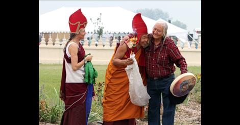 Lama Tsomo looks on  as Namchak Khenpo gets a hug  from Salish elder Stipn Smallsalmon  during Saturday’s Festival of Peace  at the Ewam Garden of 1,000 Buddhas.