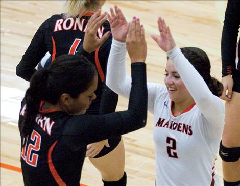Lee Camel, left, gets a high five from teammate Sadie Wirz after saving a play during a game against Troy on Saturday.