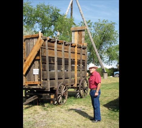 Bud Cheff Jr. stands beside the replica buffalo wagon he built.