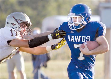 Mission Bulldog Israel Umphrey  stiff-arms a Florence defender Friday night in St. Ignatius