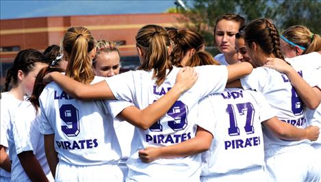 The Lady Pirate soccer squad huddles before a game.