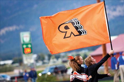 The Ronan High School cheer squad raises the school flag.