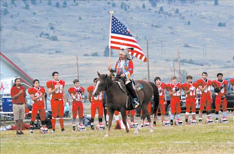 Steve Matt carries the flag during the National Anthem.