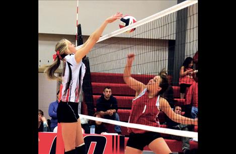 Scarlet Carly Hergett leaps for the save against Two Eagle River’s Cassadi Wunderlich during Saturday’s game in Arlee. 
