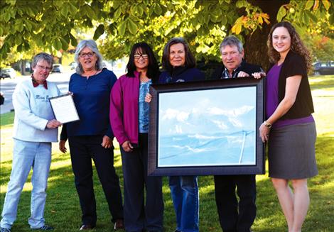 A painting donated to The Nest is displayed by Lower Flathead Valley Community Foundation board member Mary Stranahan, The Nest Executive Director Jenifer Blumberg, The Nest Secretary/Treasurer Emily Colomeda, LFVCF board members Germaine White and Rod Johnson and The Nest Vice President Brooke Roberts.