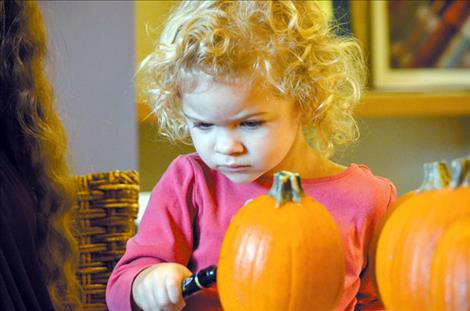  Left: KayLynne Frey, 2, colors on a pumpkin.