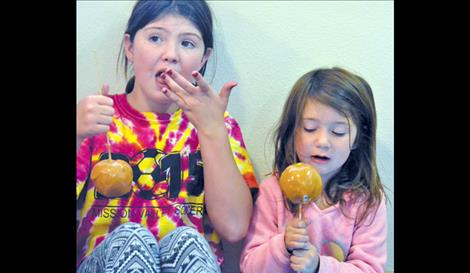 Lark Thomas, 10, and Shy Thomas, 3, enjoy caramel apples.