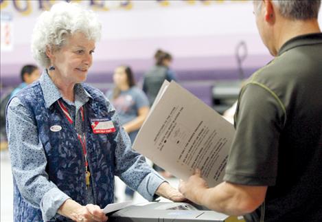 Election official Jackie Ladner helps a voter scan his ballot at Polson’s Linderman gym on Election Day.