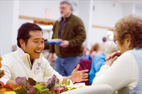 Ronald Legislador, a volunteer at last year’s community Thanksgiving dinner, chats with another volunteer during a break from kitchen duty. 