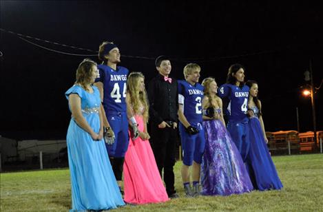 Royalty stands on the football field with soon to be crowned Nathan Doll in a pink bow tie and Jordyn Eicher in a pink gown. 