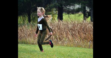 Cheetah” Lucy Montague, 5, speeds through the 1-mile course Sunday, and earns the best female superhero award. 