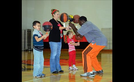 Kindergarten students Rock Bixby and Annalyse Wayman learn how to spin a ball with teacher Jessica Charette.