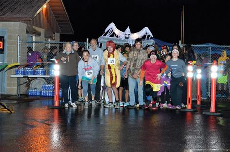 Racers take off  from the start line of the  Your Life Matters  1K fun run and 5K  Friday night at  Ronan High School.