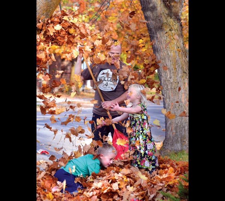 Cory Armstrong rakes leaves in front of his Polson home with “help” from his children, Landon, 8, and Viviane, 6. The pile was getting slightly smaller with each jump. “I’m letting them condense it down,” Cory said. “They are little mini-compactors.”