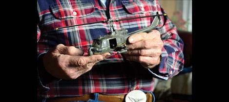 Helm holds a replica of the UH-1C Huey helicopter he went down in while serving in Vietnam.