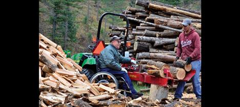 Pruitt Helm splits a pile of firewood at his home.