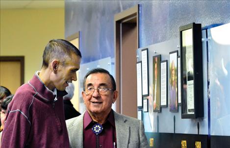 Salish Kootenai College President Robert DePoe III visits with past president Joe McDonald, right, on Monday at the unveiling of the Founder’s Wall.