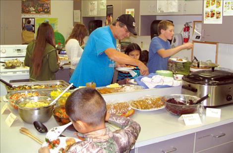 Dennis Villegas gives a blessing for the homegrown feast and then dives into the delicious dishes.