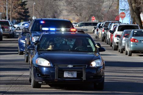 Law enforcement vehicles caravan from the memorial service to the reception.