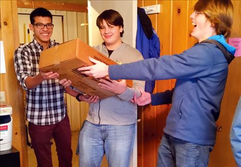 Ronan High BPA members Sam Mocabee, Trevor Blackburn and Brennan Roullier help unload 2,000 cans of food Dec. 1 at the Bread Basket in Ronan.