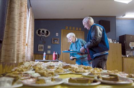 Jim and Deanne Corbett peruse the pie table at the community Thanksgiving dinner held at the Polson Senior Citizens Center last Thursday.