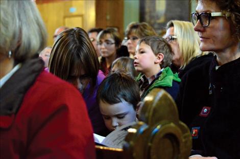 Folks watch the choir sing and some read along with the music.