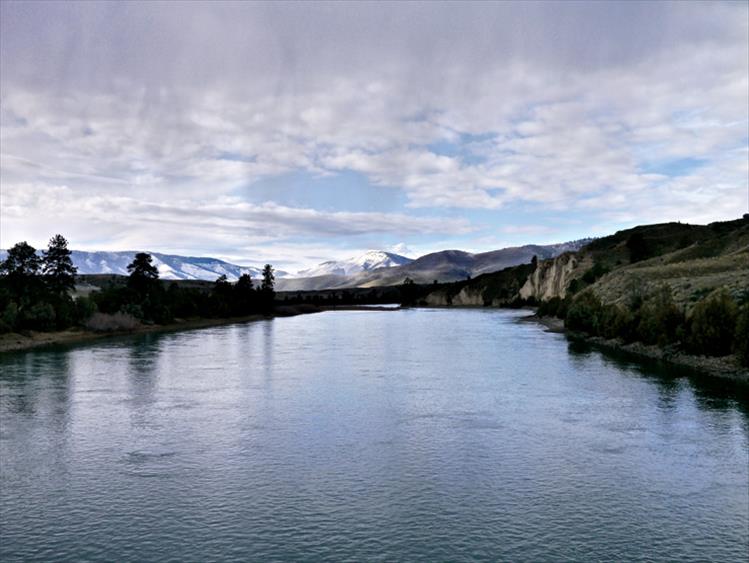The cool blue waters of the Flathead River flow smoothly beneath Sloan Bridge.