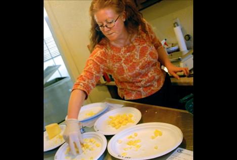 Flathead Lake Cheese maker Wendy Arnold arranges samples of the company’s cheeses during the open house on Small Business Saturday.
