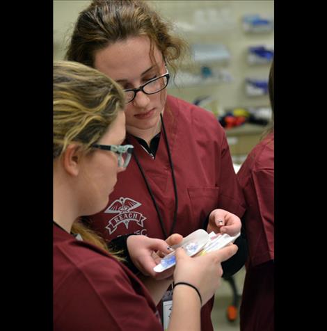 Kyla Kirsh of Charlo High examines needles.