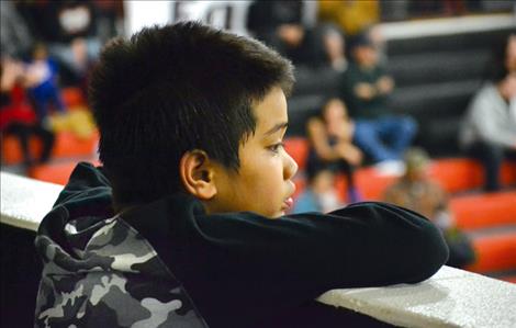 Josiah Misa watches his big brother, Aaron, play basketball.