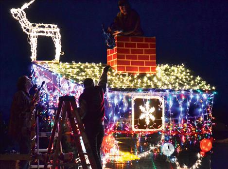 Last minute touches are placed on a float sponsored by D&D Customs/Sign Pros and Cheers, Etc., before the start of the Ronan Parade of Lights Friday night.