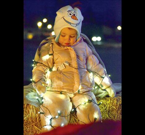 Dressed as Olaf from the movie “Frozen,” Zayla Wolfe, 2, lights up her snowsuit.