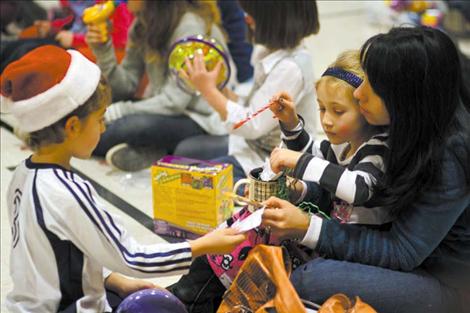 Two cheerful St. Ignatius children played with their newly-won door prizes as the festivities began to wind down Saturday night. 