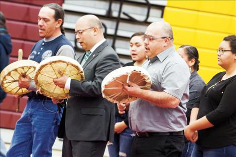 The Perez family sings an honor song with hand drums.