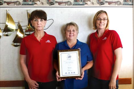 Port Polson Inn staff Val Murrin and Liz Clairmont stand with Port Polson Inn owner Anne Engebretson, center, as she displays their 500 Club award for  excellence.